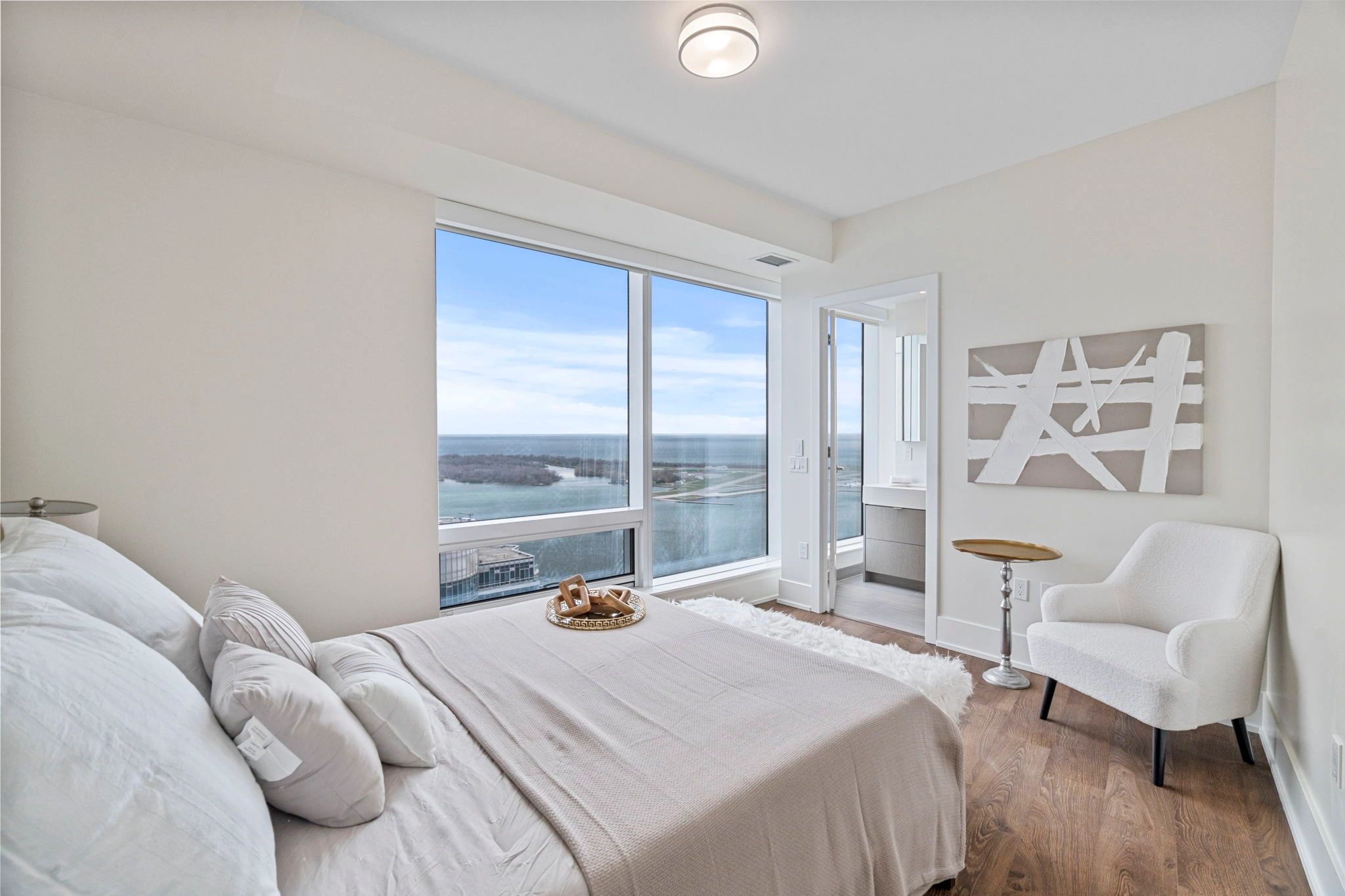A bright condo bedroom overlooking the city
